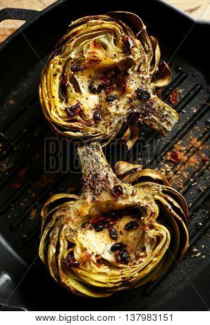 Baked artichokes on black grill pan, close up