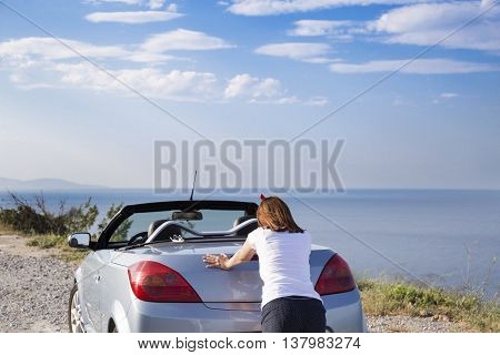 Young woman push the car runs out of gas.