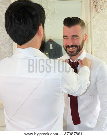 2ND JULY 2016, PORTSMOUTH,ENGLAND: A bestman helping the groom get dressed for his wedding in portsmouth, england, 2nd july 2016