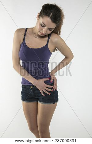 A Young Woman Is Struggling With Pain, Isolated On Background