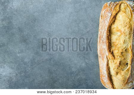 Freshly Baked Hand Crafted Rustic Bread Loaf On Dark Stone Background. Authentic Rustic Style. Lifes