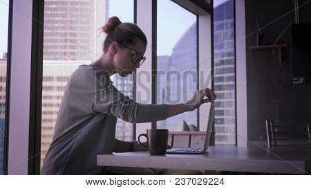 Young Business Woman In Glasses Is Working On Laptop In Office. Beautiful Female With Computer In Bu