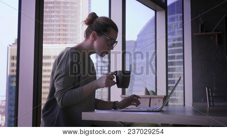 Young Business Woman In Glasses Is Working On Laptop In Office. Beautiful Female With Computer In Bu