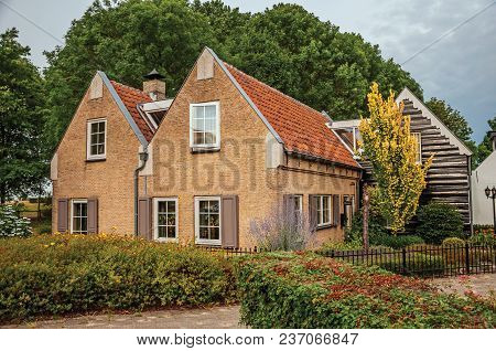 Drimmelen, Southern Netherlands - June 30, 2017. Charming Rustic House With Flowered Garden, Leafy T