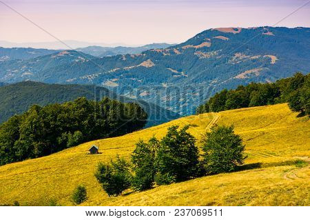 Wooden Shed On The Grassy Hillside. Beautiful Landscape With Krasna Mountain Ridge In The Distance I