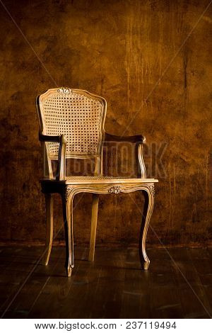 Old Chair On A Brown Wall Background