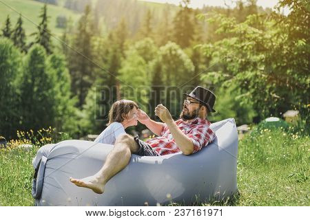 Father And Son Resting On An Air Sofa In The Mountains. Lamzac. Travel, Family Vacation In The Mount