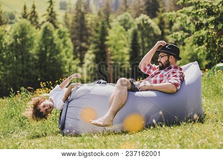 Father And Son Resting On An Air Sofa In The Mountains. Lamzac. Travel, Family Vacation In The Mount