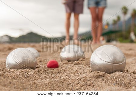 Beach. A Game Of Bocha. Brilliant Silver Balls For A Bocha On The Sand.