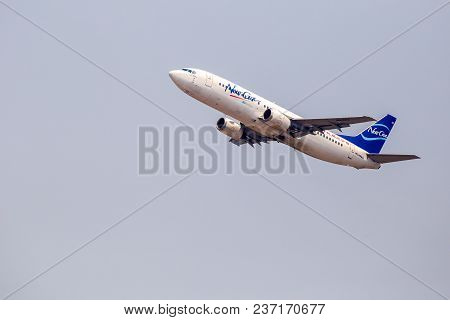 The Blue And White Boeing 737 - 800  Airplane Of Chandong Airlines Is Flying In The Hazy Sky In Chia