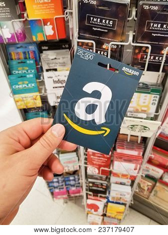Montreal, Canada - November 7, 2017: Amazon Gift Card In A Hand On Gift Cards Background. Amazon Is 