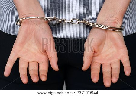 Close-up. Arrested Woman Handcuffed Hands At The Back. Prisoner Or Arrested Terrorist, Hacker, Bribe