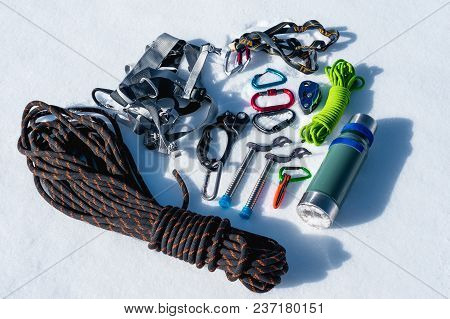 Close-up Of Winter Climbing Equipment On Fresh Snow On A Sunny Day. Carbines With A Rope Gazebo And 