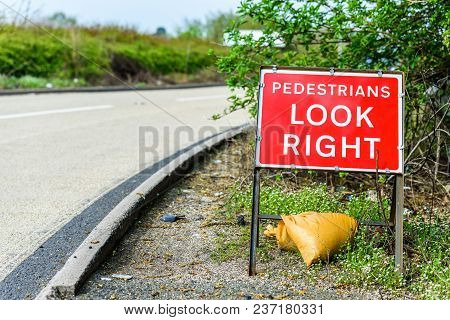 Pedestrians Look Right Roadworks Sign On Uk Motorway.