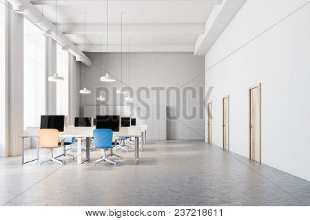 Orange And Blue Chairs Open Office Interior With A Conrete Floor, Rows Of Computer Desks And Blue An