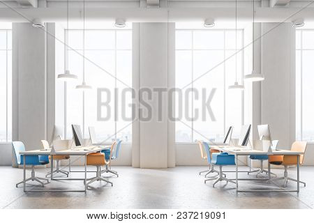 Orange And Blue Chairs Open Office Interior With A Conrete Floor, Rows Of Computer Desks And Blue An