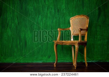 Old Chair On A Green Wall Background
