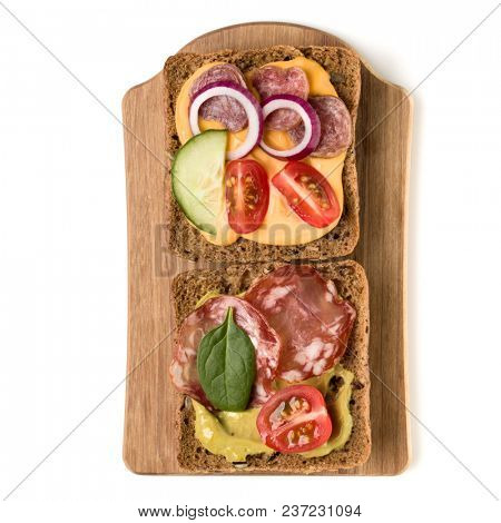 Open  faced sandwich canape or crostini on a wooden serving board  isolated on white background closeup. Top view.
