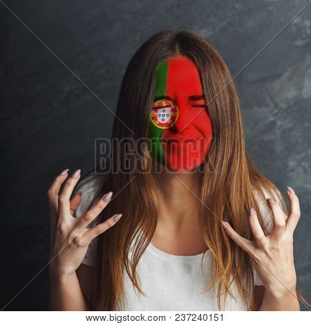 Face Of Young Desperate Woman Painted With Flag Of Portugal. Football Or Soccer Team Fan, Sport Even