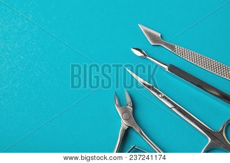 Manicure And Pedicure Beauty Accessories On Blue Background, Copy Space. Cutice Cutter And Pushers, 