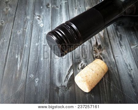 Bottle Of Wine And Cork On A Dark Wooden Table