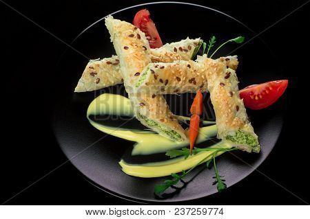 Puff Pastry With Spinach And Cheese Filling On A Black Plate And Black Background.