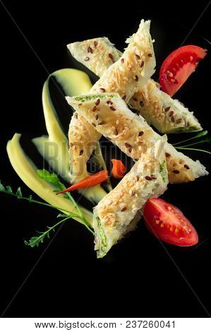 Puff Pastry With Spinach And Cheese Filling On A Black Plate And Black Background.