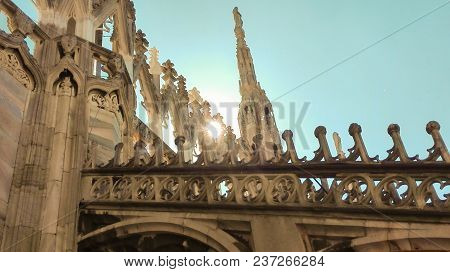 Some Spiers Of The Milan Cathedral With Sun And A  Blue Sky
