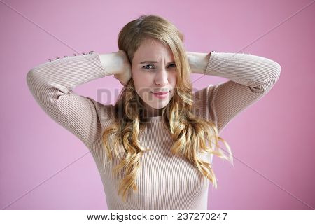 Horizontal Shot Of Stressed Attractive Young Woman Frowning, Covering Ears With Both Hands, Can't St