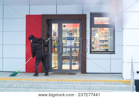 Kamensk-uralsky, Russia, February 10, 2018: Janitor Sweeps The Porch Of The Store