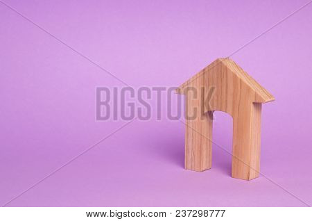 Figurine Of A Wooden House With A Large Doorway. Concept Of Real Estate, Purchase And Sale Of Housin