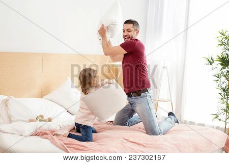 Pillow Fight. Exuberant Charming Daughter Spending With Her Daddy And Having A Pillow Battle