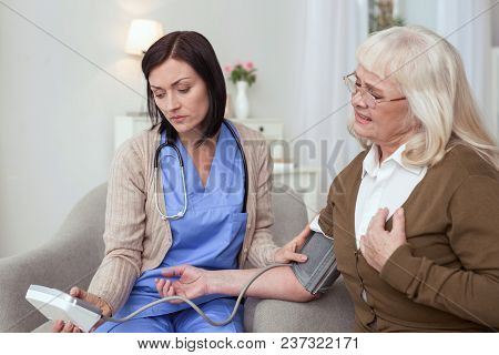 Heart Work. Attentive Caregiver Using Tonometer While Elder Woman Having Breath Problem