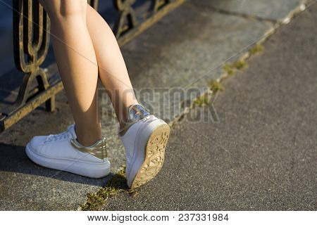 Close Up Of Beautiful Slim Legs Of Young Girl In White Sneakers Standing On Concrete Pavemen At The 