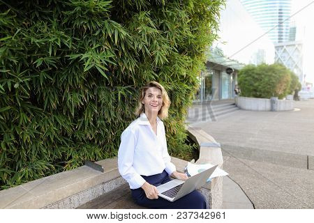Administrator Working With Laptop And Papers In Open Air Near Green Plant. Concept Of Busines, Moder