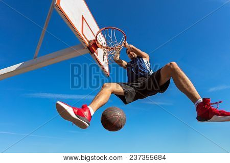 Slam Dunk. Side View Of Young Basketball Player Making Slam Dunk.
