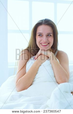 Young caucasian woman covering her head and ears with pillows