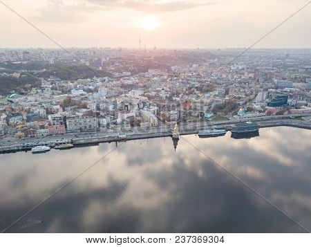 View of the Dnieper river, church of St. Nicholas on the water, River station and Naberezhno-Kreschatitska street on the sunset in Kiev, Ukraine.