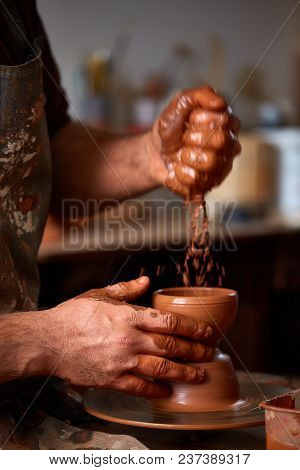 Close-up Hands Of A Male Potter In Plaid Shirt And Dirty Apron Who Molds A Vase From Clay, Selective