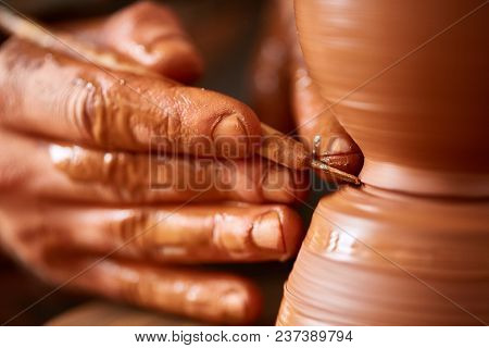 Close-up Hands Of A Male Potter In Plaid Shirt And Dirty Apron Who Molds A Vase From Clay, Selective