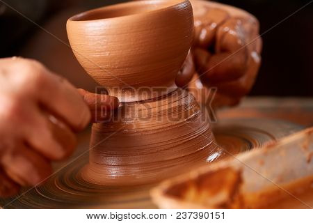 Close-up Hands Of A Male Potter In Plaid Shirt And Dirty Apron Who Molds A Vase From Clay, Selective