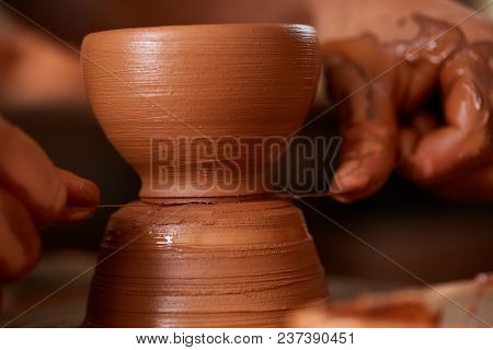 Close-up Hands Of A Male Potter In Plaid Shirt And Dirty Apron Who Molds A Vase From Clay, Selective