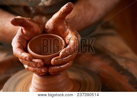 Close-up Hands Of A Male Potter In Plaid Shirt And Dirty Apron Who Molds A Vase From Clay, Selective