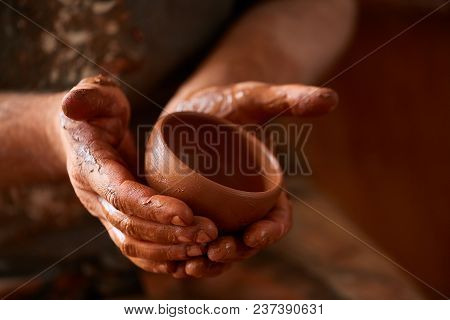 Close-up Hands Of A Male Potter In Plaid Shirt And Dirty Apron Who Molds A Vase From Clay, Selective