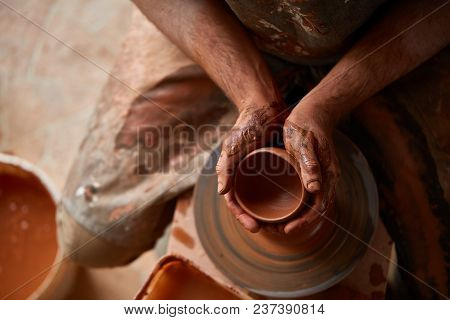 Close-up Hands Of A Male Potter In Plaid Shirt And Dirty Apron Who Molds A Vase From Clay, Selective