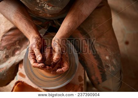 Close-up Hands Of A Male Potter In Plaid Shirt And Dirty Apron Who Molds A Vase From Clay, Selective