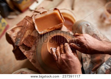 Close-up Hands Of A Male Potter In Plaid Shirt And Dirty Apron Who Molds A Vase From Clay, Selective