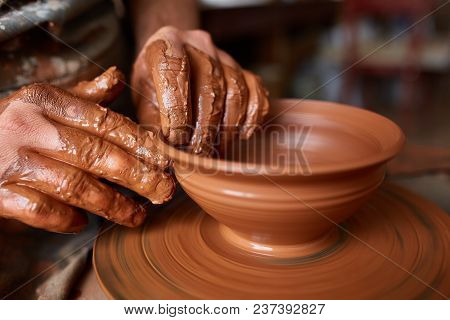 Close-up Hands Of A Male Potter In Plaid Shirt And Dirty Apron Who Molds A Vase From Clay, Selective