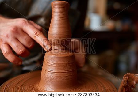 Close-up Hands Of A Male Potter In Plaid Shirt And Dirty Apron Who Molds A Vase From Clay, Selective