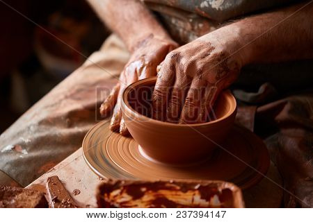 Close-up Hands Of A Male Potter In Plaid Shirt And Dirty Apron Who Molds A Vase From Clay, Selective